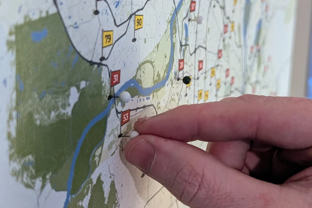 A push pin pressed into a framed map of St. Louis golf courses